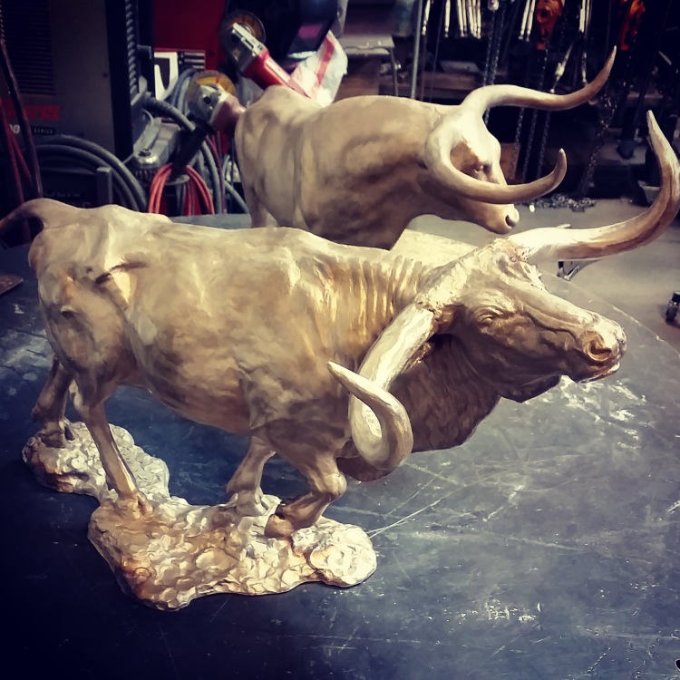 Two bronze statues of bulls.